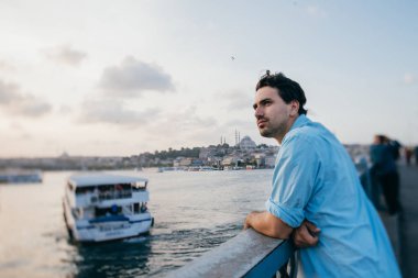 Köprüde genç bir adam şehrin uzaklığına bakıyor.. 