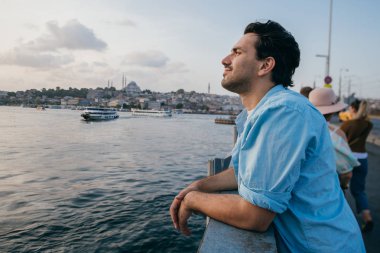 Köprüde genç bir adam şehrin uzaklığına bakıyor.. 