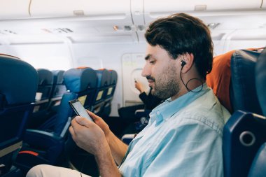 Adam uçakta uçuyor, müzik dinliyor..