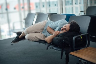 Havaalanındaki adam kalkışı bekliyor, uyuyor.