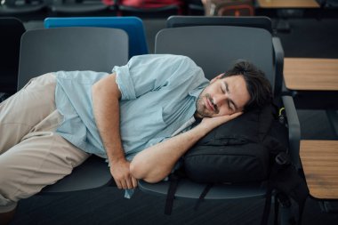 Havaalanındaki adam kalkışı bekliyor, uyuyor.