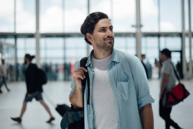 Havaalanında sırt çantası olan adam.