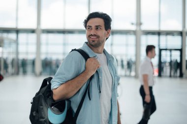 Havaalanında sırt çantası olan adam.