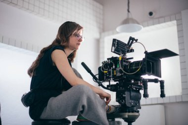 Bir kadın, kameranın arkasındaki vinçteki kameramandır. Film çekiyoruz. İşyerinde çalışan genç bir kız.