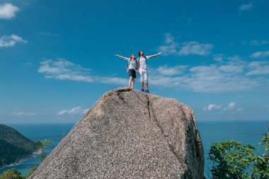 Okyanusun destansı manzarasına sahip bir çift kayanın üzerinde duruyor. Popüler bir turizm merkezi. Sevgililer tropik bölgelerde tatildeler. Tropiklerde balayı.