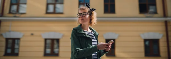 電話のある女性がヨーロッパの通りに行く 若い女の子は オンラインで通信し 航海士の道を探し 晴れた日に街を歩き回る — ストック写真