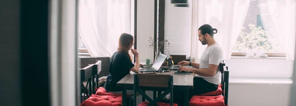 남녀가 탁자에서 일하고 부부가 거실에 책상에 노트북을 가지고 기간에 집에서 — 스톡 사진