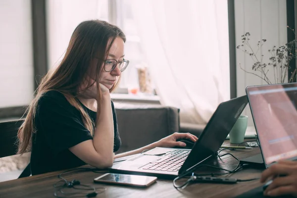 여자가 탁자에서 안경을 소녀는 탁자에 노트북을 기간에 집에서 일하라 — 스톡 사진