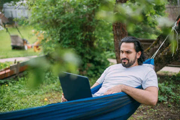 Een Man Werkt Met Een Laptop Een Hangmat Een Landhuis — Stockfoto