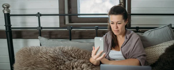 Mujer Trabaja Con Ordenador Portátil Teléfono Cama Dormitorio Una Joven —  Fotos de Stock