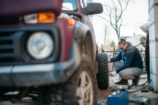 Man Repairs Car Puts Wheels Changes Seasonal Tires Young Guy — Stock Photo, Image