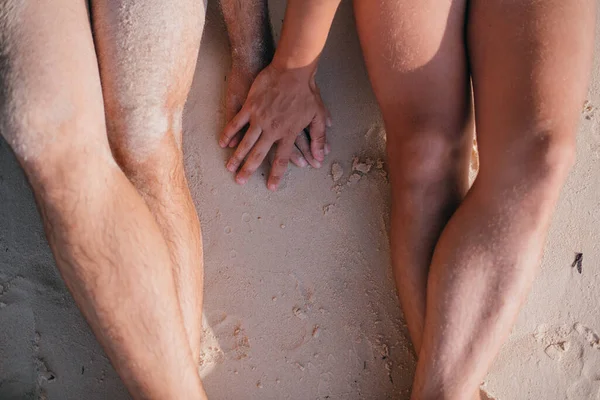 两个快乐的男人手牵着手坐在海边的沙滩上 看不到脸 同性恋假期 同性恋之旅 — 图库照片