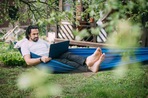 Ein Mann Arbeitet Mit Einem Laptop Einer Hängematte Einem Landhaus — Stockfoto