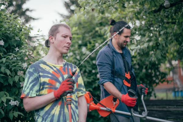 Dois Homens Estão Trabalhar Jardim Eles Cortam Grama Com Cortador — Fotografia de Stock