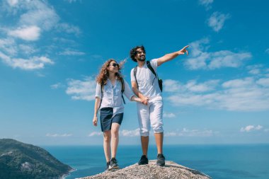 Okyanusun destansı manzarasına sahip bir çift kayanın üzerinde duruyor. Popüler bir turizm merkezi. Sevgililer tropik bölgelerde tatildeler. Tropiklerde balayı.