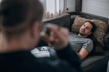 Psikoterapist ve hasta ofiste bir randevuda. Genç bir erkek hasta büyük, parlak bir ofiste kanepede yatıyor. Doktor müşterinin geçmişini kaydediyor..