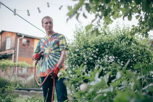 Homem Está Regando Jardim Com Uma Mangueira Jovem Trabalhar Roupas — Fotografia de Stock