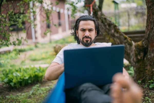 Een Man Werkt Met Een Laptop Een Hangmat Een Landhuis — Stockfoto