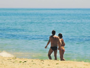 Denize giren bir kadın olan bir adam.