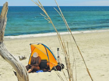 Gölgenin altında okuyan bir kadın.