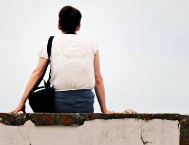 Duvara ayakta beyaz bluz ile kadın