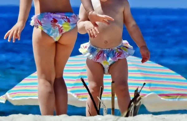 Two children play on the sand on the beach