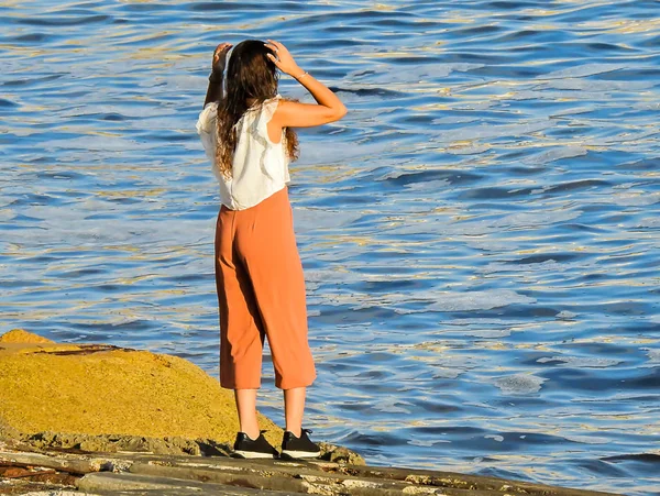 Jonge Vrouw Kijkt Uit Met Haar Handen Haar Hoofd — Stockfoto