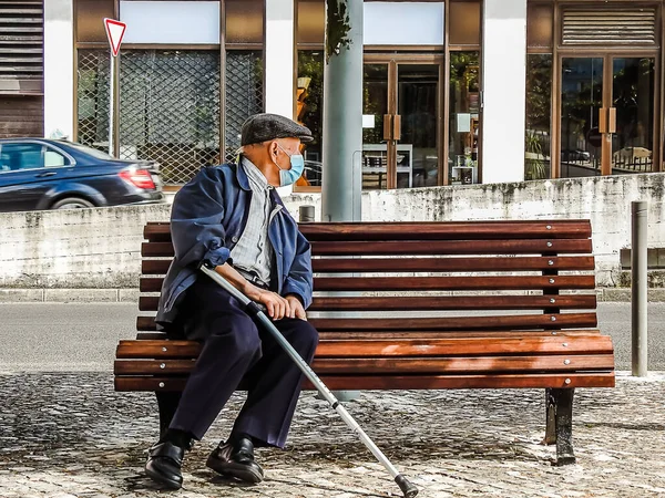 大流行病期间 一位戴着口罩坐在长椅上的老人 — 图库照片
