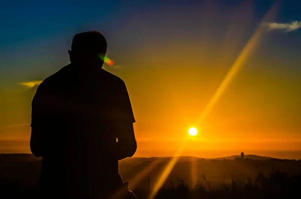 The silhouette of a man in the light of the sunset in natural light effects