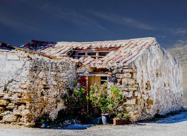 Akşamları çatısı delinmiş ve duvarları soyulmuş harap bir ev.
