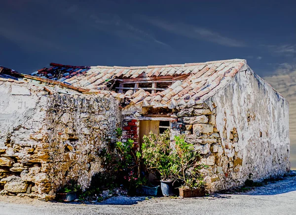 Akşamları çatısı delinmiş ve duvarları soyulmuş harap bir ev.