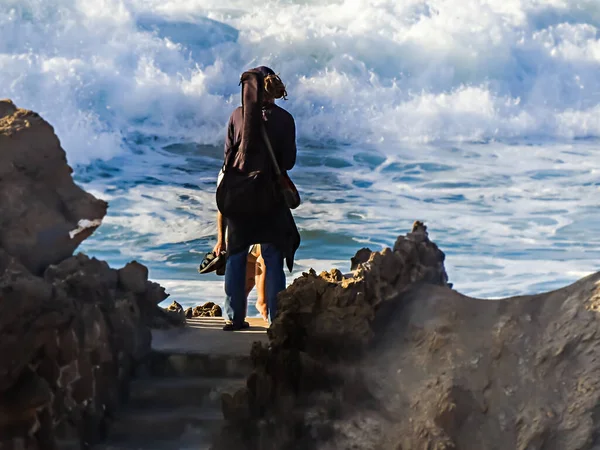Человек Гитарой Позади Разговаривает Океана Женщиной Стоящей Перед Ним — стоковое фото