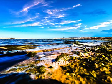 Ufukta deniz manzarası ve bulutlu mavi gökyüzü var.