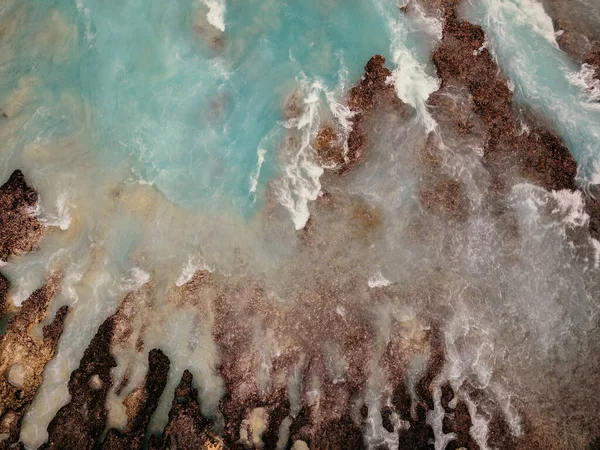 Birds eye view of turquoise water and foam in Nusa Penida, Indonesia. Abstract background, drone photography