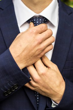 Damat kravatını kendi elleriyle düzeltir.