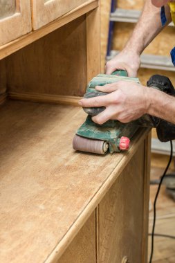 Marangoz, ahşabı eski haline getiriyor öğütme makinesinin elektriğiyle bir büfe yapıyor..