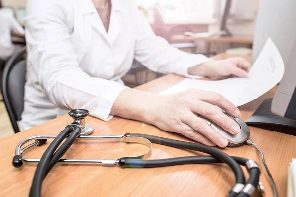 Bilgisayardaki Bir Doktor Steteskopun Yanındaki Masada Bulunan Hastanın Tıbbi Araştırmalarının — Stok fotoğraf