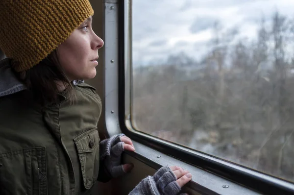 Piękna Dziewczyna Wełnianym Kapeluszu Podróżuje Pociągiem Patrząc Przez Okno Niebo — Zdjęcie stockowe