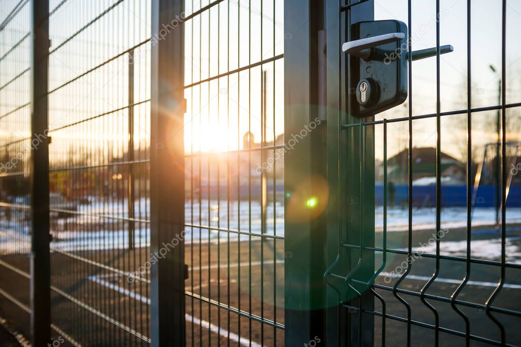 entrance to the playground of fence and the wicket of the welded wire mesh green color with a metal lock and handle