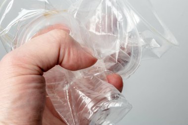 Elinde birkaç tane buruşmuş şeffaf plastik bardak tutan kişi. Çevresel sorun kavramı. 