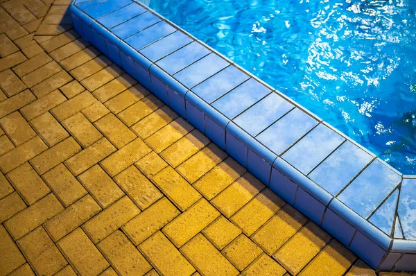 Yellow is not slippery, safe tile on the floor and blue in the pool with transparent fresh water, indoors.