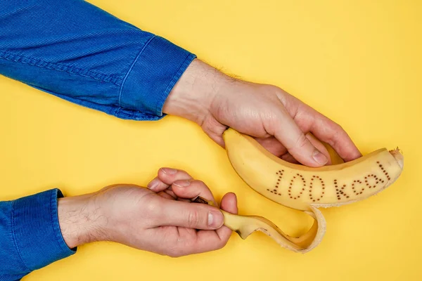 Mão Homem Uma Camisa Veludo Segura Uma Banana Casca Qual — Fotografia de Stock