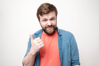 İğneleyici, kurnaz, sakallı bir adamın baş parmağını kaldırma hareketi. Beyaz arkaplanda izole.