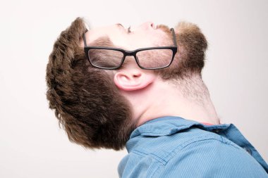 Yan tarafına gözlük takan sakallı bir adamın profili ve kulak bir ağıza dönüştü. İlginç, komik bir fikir. Beyaz bir arkaplanda izole edilmiş.