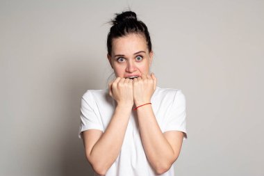 Yüzünde şok ifadesi olan, gözleri sonuna kadar açık ve elleri heyecandan ağzı kaplayan bir kadın. Beyaz arkaplan üzerinde izole edilmiş.