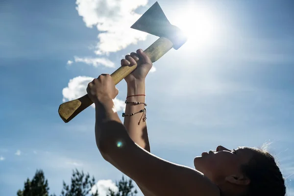 一个女人在蓝天 太阳和树梢的映衬下手里拿着一把斧头 两性平等和现代妇女的概念 后续行动 — 图库照片