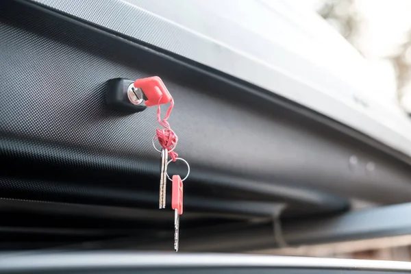 Lock with keys in the trunk or cargo box on the roof of the car, for the safety of things. Close-up.