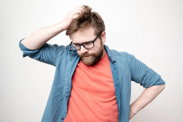 Young Bearded Man Glasses Doubt Confused Looks Thoughtfully Scratches His — Stock Photo, Image