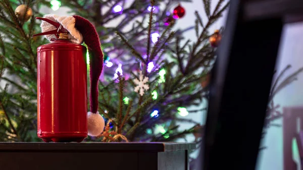 圣诞前夕 圣诞老人戴着红色的帽子 站在一棵黑色的木制桌子上 背景是圣诞树 装饰着五彩缤纷的花环和玩具 气氛温馨宜人 安全概念 — 图库照片