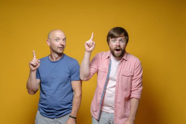 Harika bir fikir. İki komik adam işaret parmaklarını kaldırır ve kameraya neşeyle, entrikayla bakar.. 